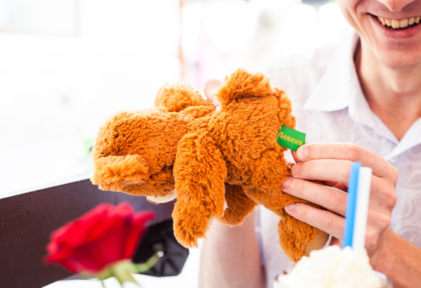 людина з пухнастим іграшковим ведмедем
 - Фото, зображення