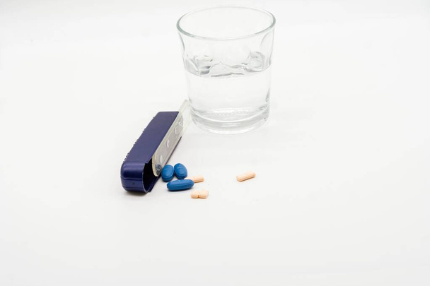 Water glass and weekly pill box. Isolated on white background - 写真・画像