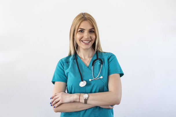 Beautiful young female medical doctor is looking at camera and smiling Shot of a female doctor standing confidently with her arms crossed - Photo, Image