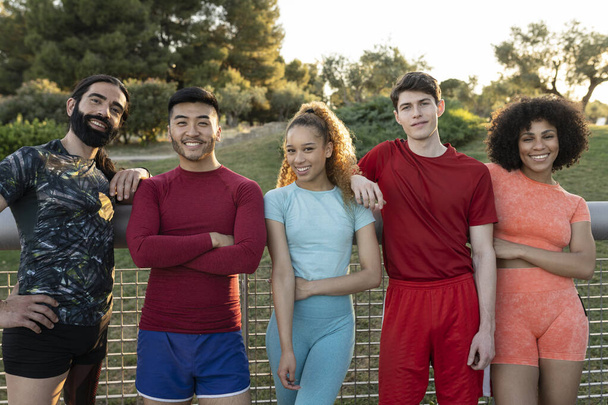 Gruppe gutaussehender multiethnischer sportlicher Freunde, die nach dem Sport in die Kamera lächeln - Foto, Bild