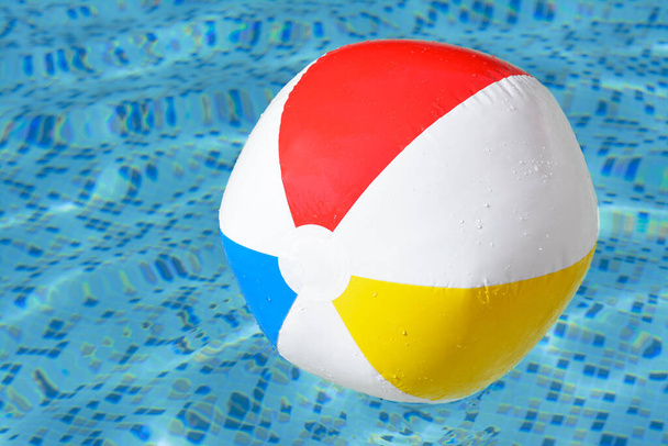 Inflatable beach ball floating in swimming pool, closeup - Zdjęcie, obraz