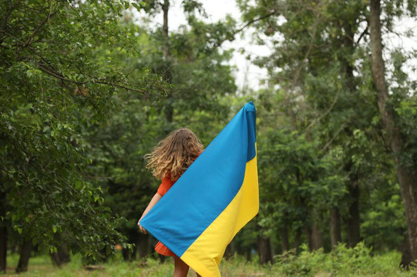 Teenage girl with flag of Ukraine outdoors - Photo, image