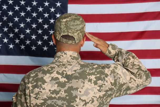 Soldier in uniform against United states of America flag, back view - Photo, image