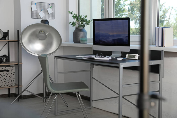 Professional lighting equipment and comfortable workplace in photo studio. Interior design - Zdjęcie, obraz