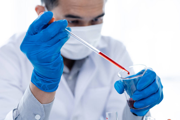 Laboratory assistants are investigating chemical reactions, medical scientists, chemical researchers, chemical experiments and disease testing from patient blood samples. Medicine and research concept - Photo, image