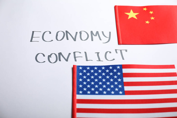 USA and China flags near words ECONOMY CONFLICT on white background - Foto, imagen