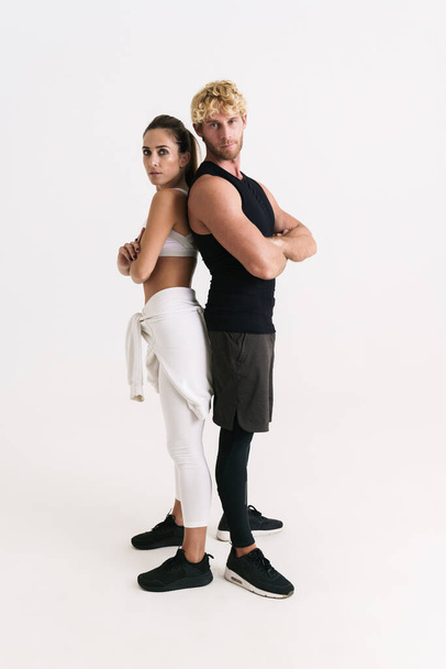 European man and woman in sportswear posing with arms crossed isolated over white background - Fotografie, Obrázek