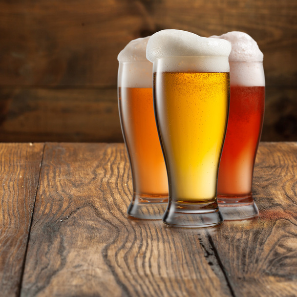 Bier in Gläsern auf Holz - Foto, Bild