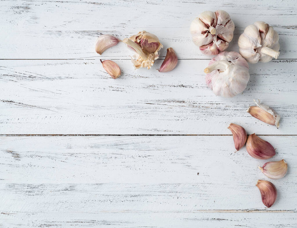 Garlic bulb and cloves over wooden table with copy space. - Foto, Imagen