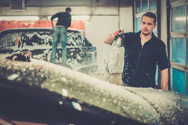 Mann wäscht Luxusauto in einer Waschanlage - Foto, Bild