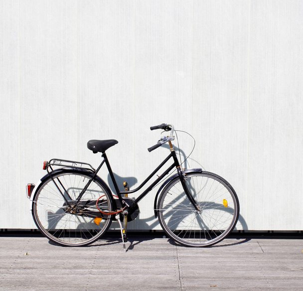 A bike leaning on a wall - 写真・画像