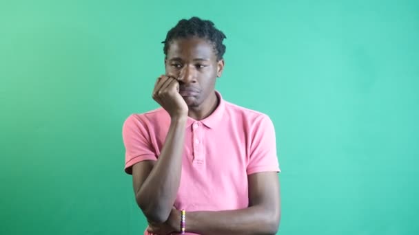 Black mans overthinking facial expression, models solitary thinking gestures, image of emotions and facial expressions taken in front of the green curtain - Materiał filmowy, wideo