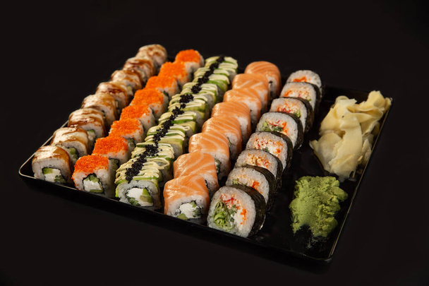 Sushi and fried garlic shrimps, prawn on a stone plate with black background - Foto, immagini