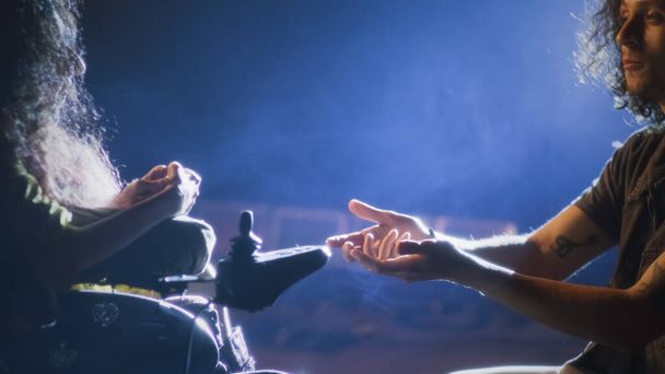 Egy romantikus előadás próbája közben egy színész térden állva énekel egy dalt egy fogyatékos színésznőnek a színpadon, reflektorfényben megvilágítva. - Fotó, kép