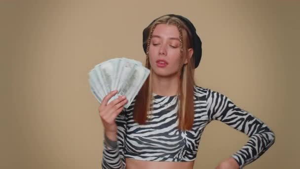 Rich pleased boss pretty young woman waving money dollar cash banknotes bills like a fan, success business career, lottery winner, big income, wealth. Adult stylish girl isolated on beige background - Felvétel, videó