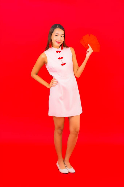 Portrait beautiful young asian woman with red envelope letter on red background - Zdjęcie, obraz