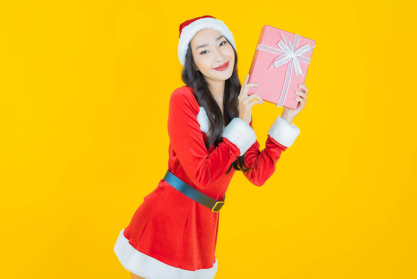 Portrait beautiful young asian woman wear christmas costume with red gift box on color background - Foto, Imagen