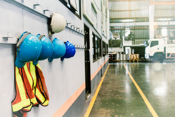 Nobogy Industriële werkplekken, helmen en veiligheidsvesten van leidinggevenden en medewerkers hangen voor de fabriekskantoorwinkel voor de veiligheid. - Foto, afbeelding