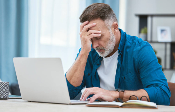 Sometimes business is a headache. a mature businessman experiencing a headache while working on his laptop - Φωτογραφία, εικόνα
