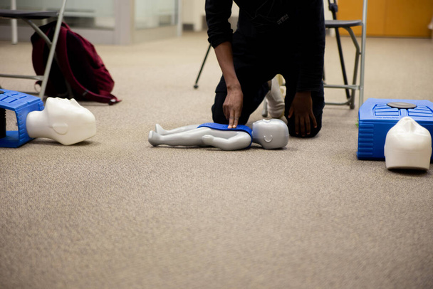 Персонал, який практикує першу допомогу cpr з пальцями та машиною AED
 - Фото, зображення
