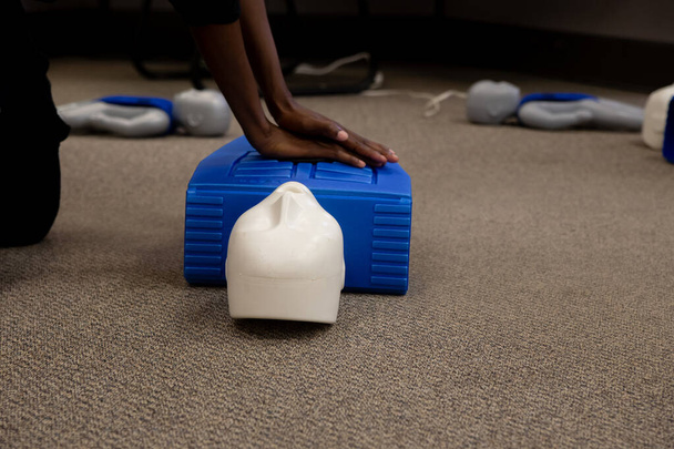 Staff practicing first aid cpr with their fingers and AED machine - Fotoğraf, Görsel