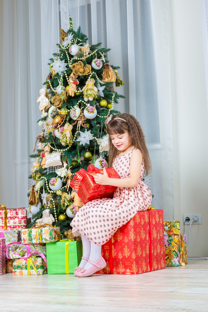 Happy little girl with christmas present smiling - Foto, immagini