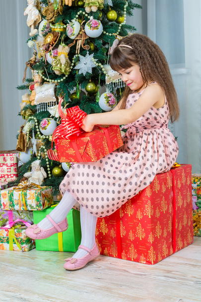Happy little girl with christmas present smiling - Fotografie, Obrázek