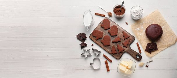 Lekkere chocolade Kerstkoekjes, deeg en ingrediënten op witte houten ondergrond met ruimte voor tekst - Foto, afbeelding