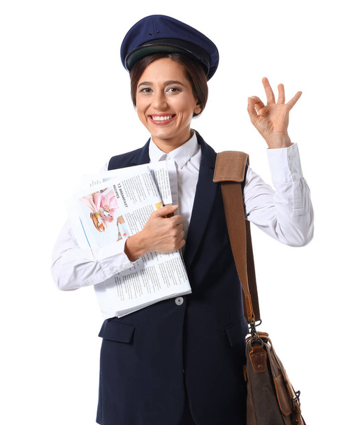 Female postman with newspapers and bag showing OK on white background - Fotografie, Obrázek