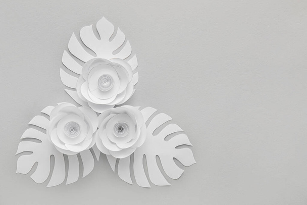 Composition with white paper flowers and leaves on grey background - Photo, Image