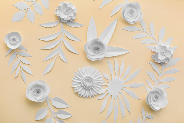 Paper flowers with leaves on beige background - Φωτογραφία, εικόνα