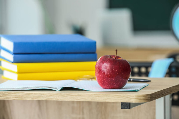 Apple with school books on table in classroom, closeup - Foto, immagini