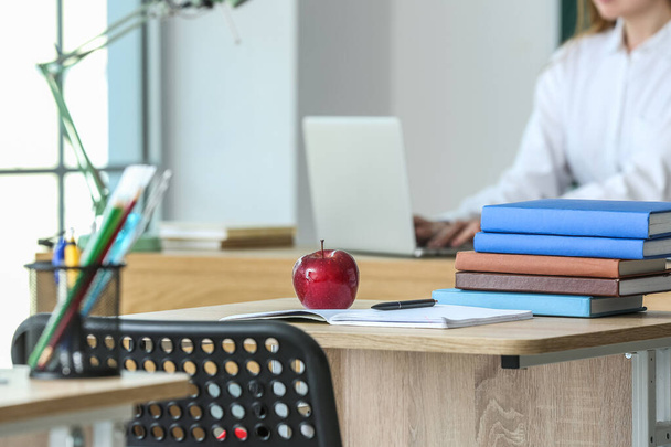 Red apple with school books on table in classroom - Foto, Imagen