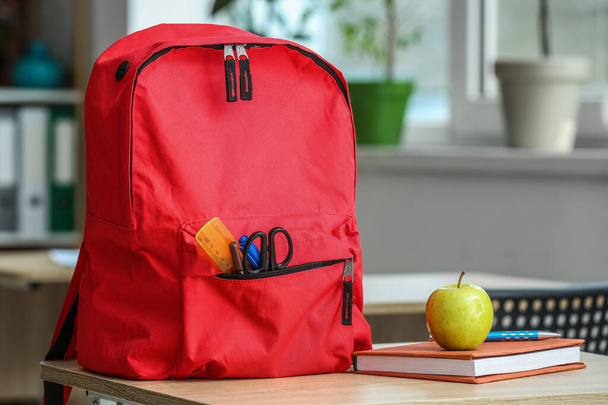 Apple with book and school backpack on table in classroom - Photo, Image