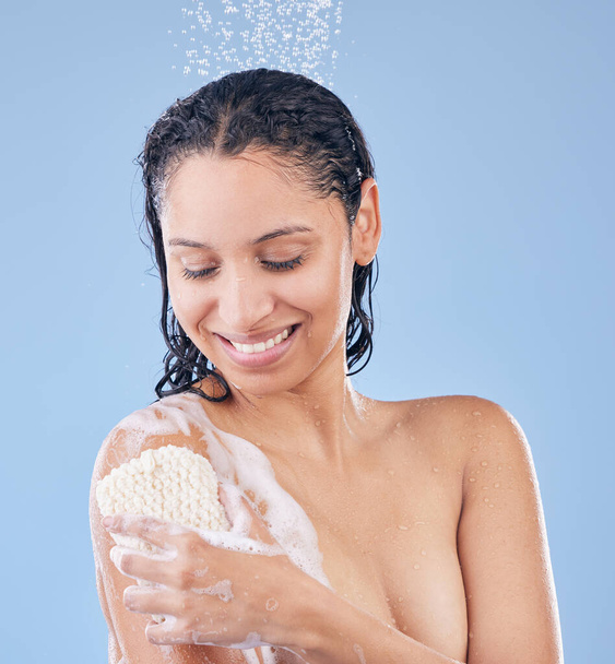 I love how it smells and makes my skin feel. a young woman using a sponge while taking a shower - Fotoğraf, Görsel