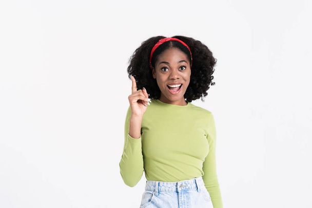 Young black woman smiling and pointing finger upward isolated over white background - Foto, Bild