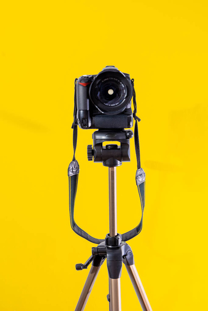 DSLR camera on yellow background - Foto, Bild