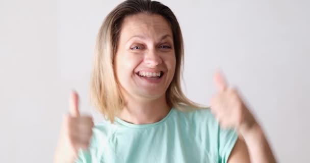 Smiling woman dancing and showing thumbs up on white background 4k movie. Service quality positive mood concept - Footage, Video