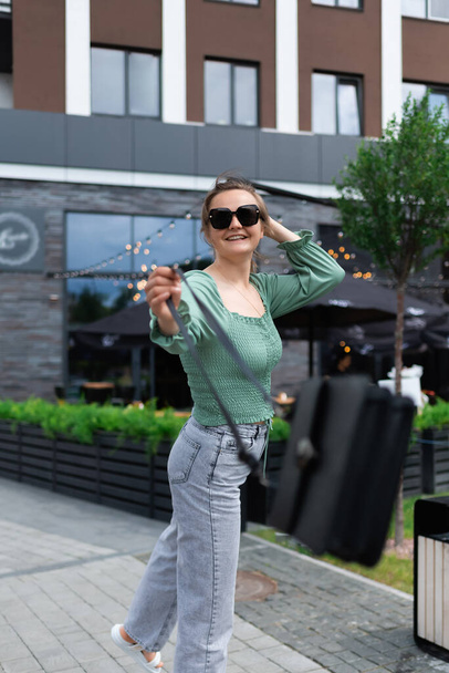 A woman in sunglasses is dancing while walking in the city. Feel happy no matter what - Photo, image