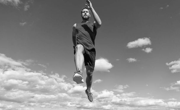 muscular man sprinter running in sportswear outdoor on sky background, marathon. - Фото, зображення