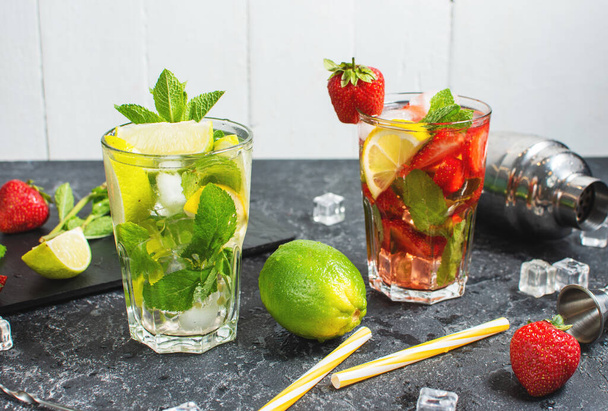 Fresh Mojito cocktail set with lime, mint, strawberry and ice in glass on stone background. Summer cold alcoholic non-alcoholic drinks, beverages. Steel bar tools. - Фото, изображение
