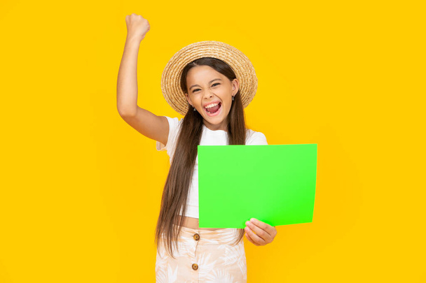 successful teen kid with copy space on green paper on yellow background. - Photo, image