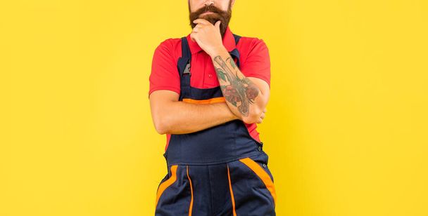 cropped thinking man loader in work clothes on yellow background. - Foto, Imagem