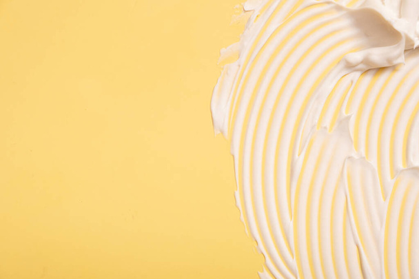 Close-up creme hidratante mancha mancha textura ondulada no fundo colorido com espaço de cópia. Produto de beleza de cuidados com a pele. - Foto, Imagem