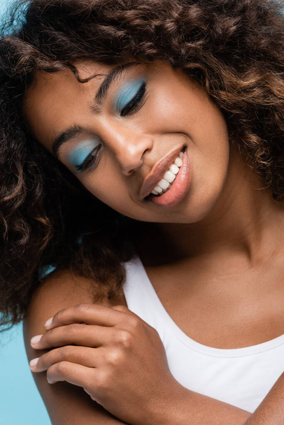 close up portrait of happy african american woman with perfect skin and makeup with blue eye shadows - Photo, Image