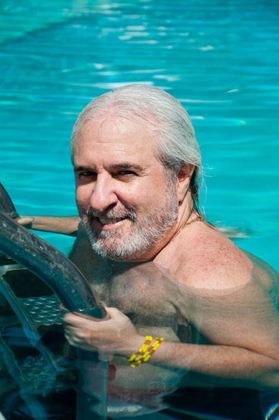 grizzled man in caribbean pool. summer vacation in caribbean. man swim in caribbean resort. - Foto, Imagen