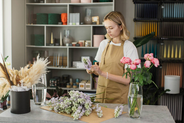 Small business. Female florist in flower shop. Floral design studio, making decorations and arrangements. Flowers delivery, creating order. - 写真・画像