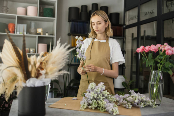 Small business. Female florist in flower shop. Floral design studio, making decorations and arrangements. Flowers delivery, creating order. - Foto, Bild