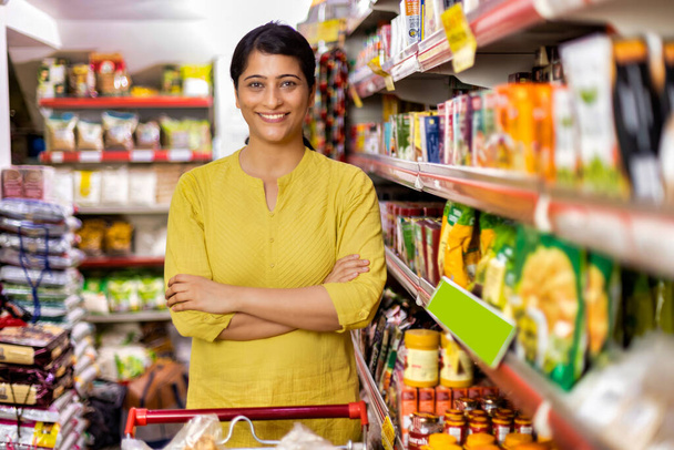 Happy woman owner with arms crossed at grocery aisle of supermarket - Photo, Image