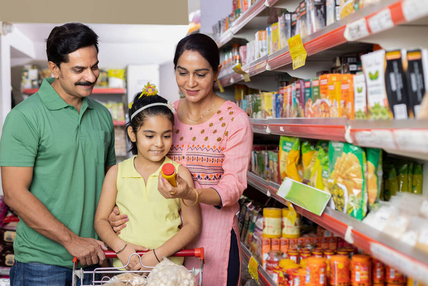 Happy family shopping for groceries at the supermarket - Foto, imagen
